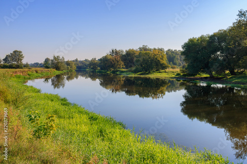 River on a background of blue sky at sunny summer morning. River landscape