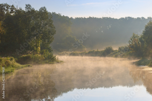 Fog over river surface in sunny summer morning. River landscape