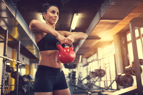 Female use kettle bell weight for exercising muscles