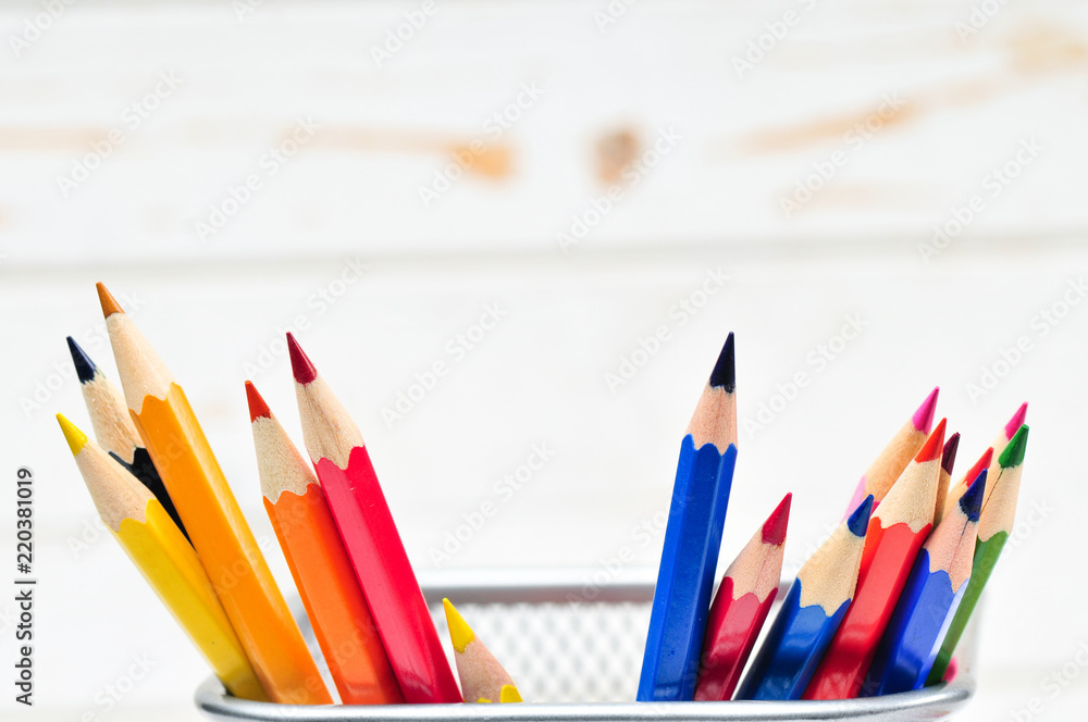 Colored pencils in pencil case on wooden background.
Colored pencils in pencil case on wooden background.