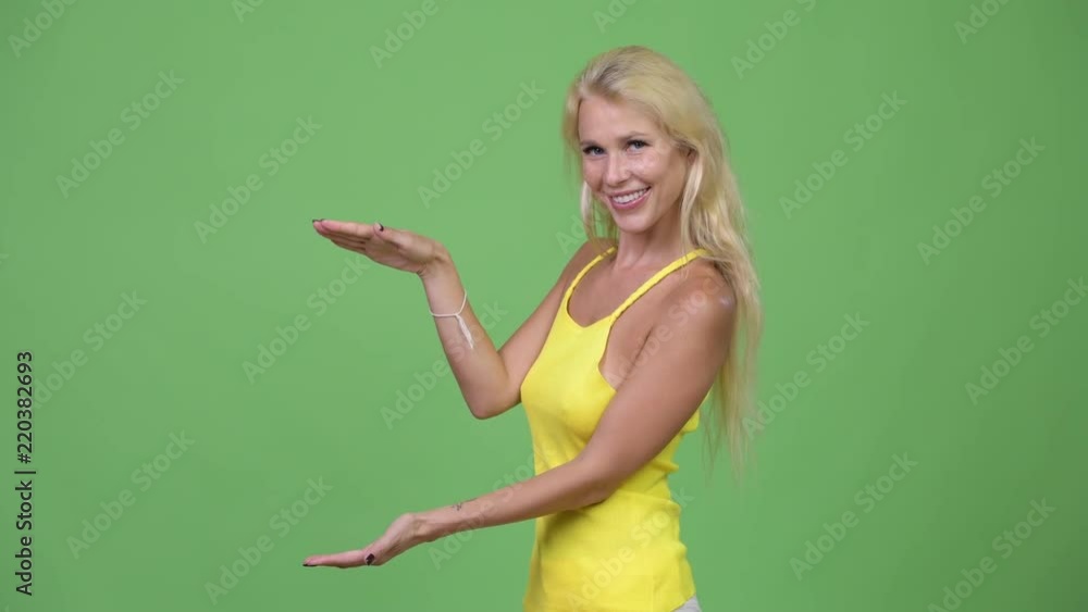 Young happy beautiful blonde woman snapping fingers and showing something Young happy beautiful blonde woman snapping fingers and showing something