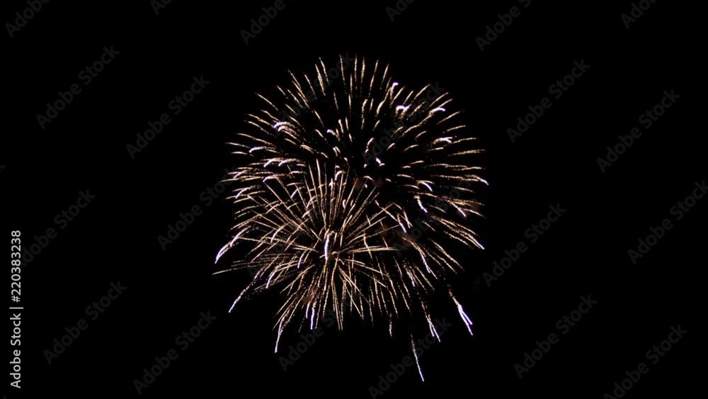 A beautiful fireball is in the middle of the night sky. Yellow saturated color, many sparkling lines and shine. Two fireworks are intertwined, there is smoke around. A beautiful fireball is in the middle of the night sky. Yellow saturated color, many sparkling lines and shine. Two fireworks are intertwined, there is smoke around.