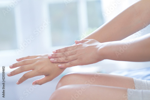 young woman hands are applying some lotion on her beauty skin