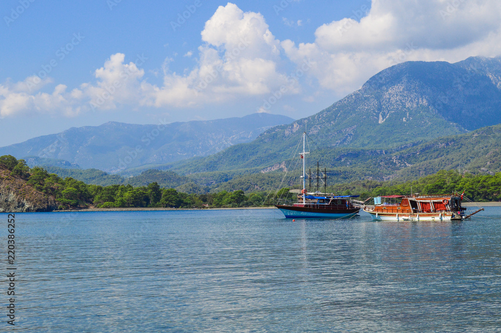 Picturesque coast of the Mediterranean Sea near the Phaselis. Two boats are moored in a bay. Mountains on the background.