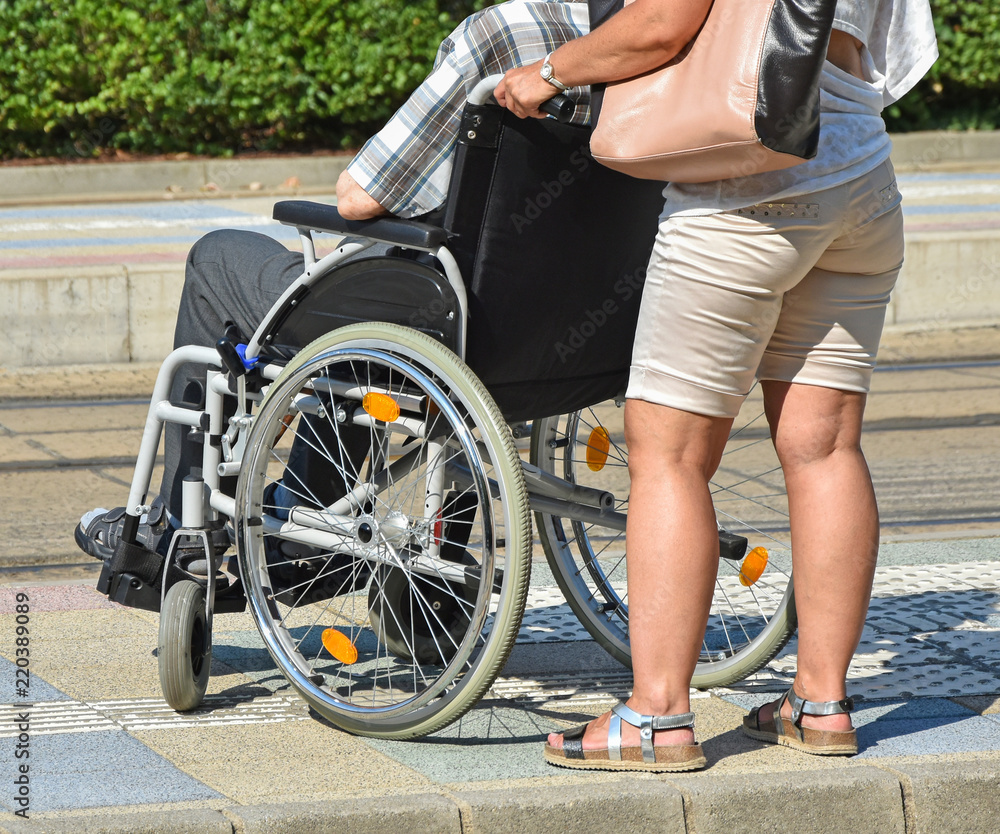 Obraz premium Old man in a wheelchair and a woman