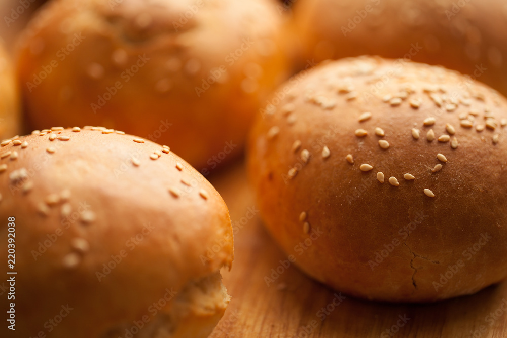 background of homemade buns with sesame seeds for hamburgers. made at home bread. natural product. background of homemade buns with sesame seeds for hamburgers. made at home bread. natural product.