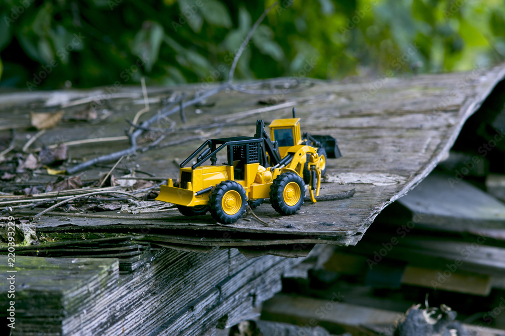 The two bulldozer lying on the top of a wooden plank. The two bulldozer lying on the top of a wooden plank.