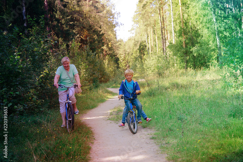 active senior grandmother with kids riding bikes in nature