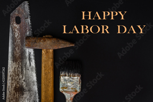 Construction worker tools builder hammer, saw, nails, screwdrivers on black background flat view from above, concept of labor and business and holiday builder day and father's day