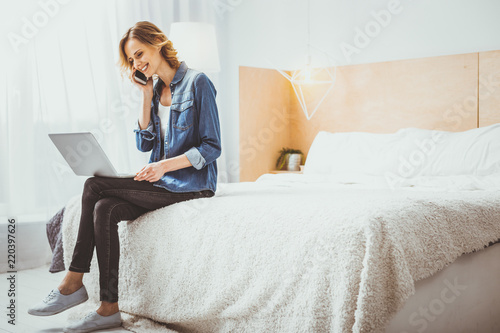 Joyful mood. Nice girl communicating with her partner while her notebook sleeping