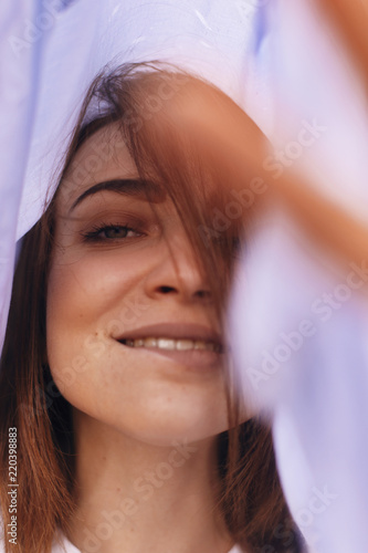 Portrait of fashion beauty woman which hiding under her blue shirt. woman with clean happy face
