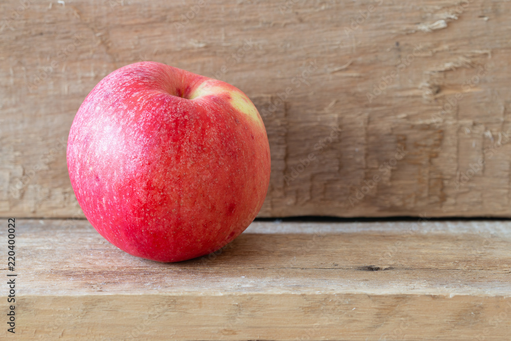 Natural full red apple on a wooden plank Natural full red apple on a wooden plank