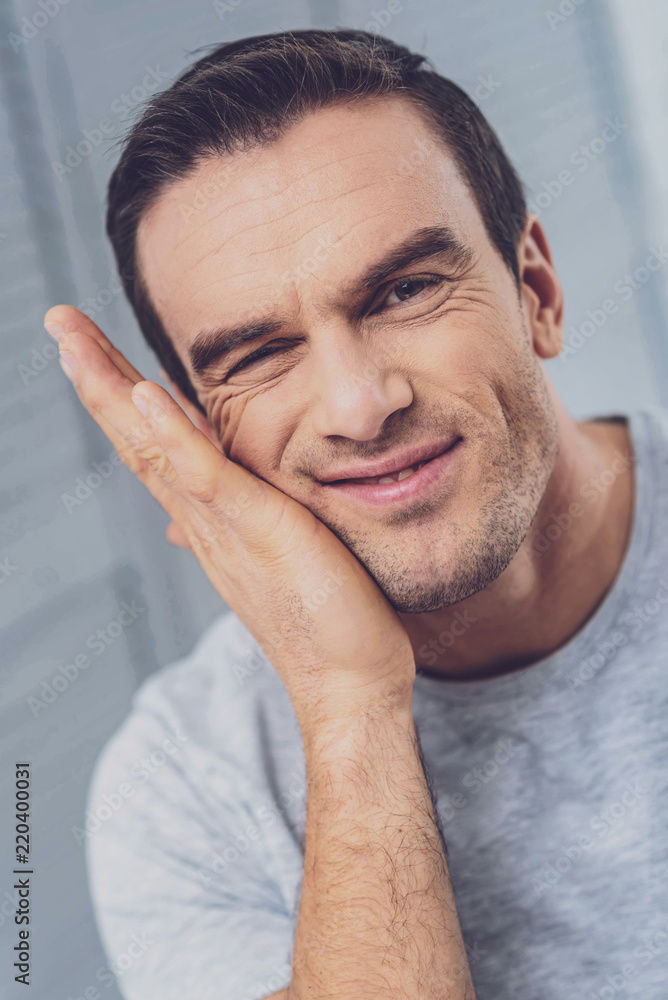 Obraz premium Touching face. Handsome hazel-eyed man touching his wrinkled face while feeling very thoughtful about upcoming situation