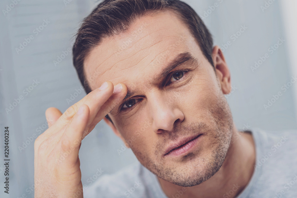 Having migraine. Mature man feeling rather awful touching his eyebrow while having strong migraine after weather changes Having migraine. Mature man feeling rather awful touching his eyebrow while having strong migraine after weather changes