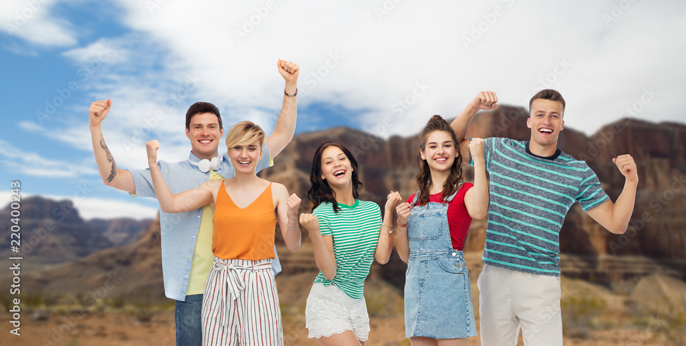 travel, tourism and summer holidays concept - group of happy smiling friends making fist pump gesture over grand canyon national park background travel, tourism and summer holidays concept - group of happy smiling friends making fist pump gesture over grand canyon national park background