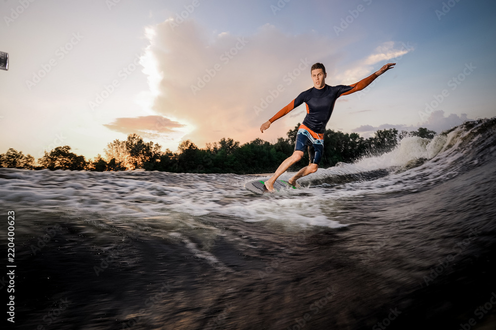 Active male wakeboarder riding on the board