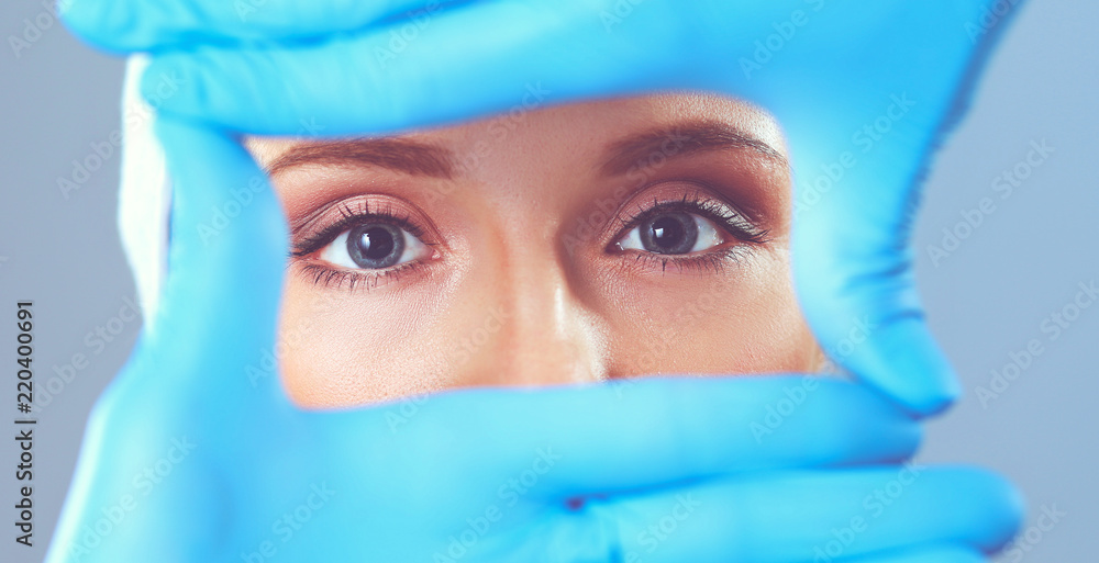A surgeons hands touching a female face A surgeons hands touching a female face