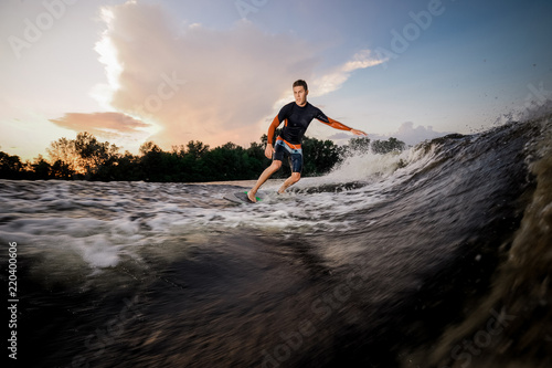 Attractive male wakeboarder riding on the board