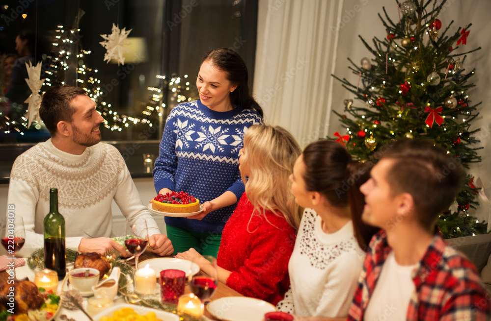 holidays and celebration concept - happy friends having christmas dinner at home holidays and celebration concept - happy friends having christmas dinner at home