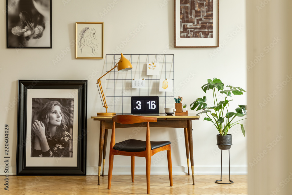 Φωτογραφία Wooden chair at desk with yellow lamp and laptop in home office interior with gallery