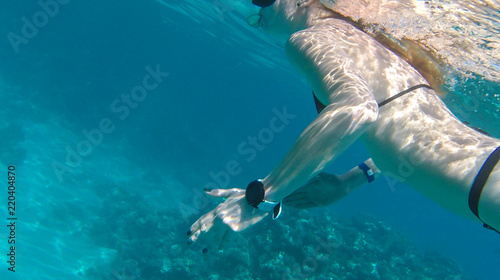 Girl swims near coral in red sea. © Yaroslav