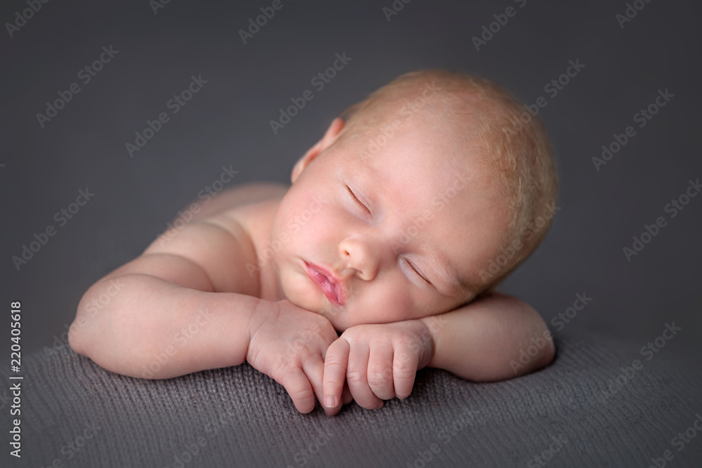 Newborn baby girl on gray knit blanket folded hands - obrazy, fototapety, plakaty 