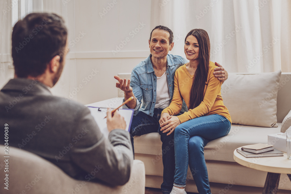 Happy together. Attractive longhaired woman keeping smile on her face while sitting near her Happy together. Attractive longhaired woman keeping smile on her face while sitting near her