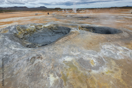 hverir geothermal area in iceland, active mud pod with steam and people in background