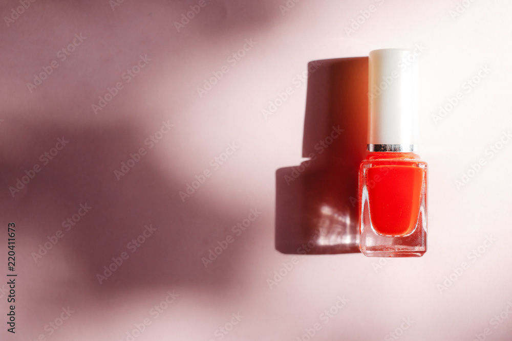 multi-colored nail polishes on pastel pink background, top view, Flat lay. Many round jars with multi-colored for nail polish. multi-colored nail polishes on pastel pink background, top view, Flat lay. Many round jars with multi-colored for nail polish.