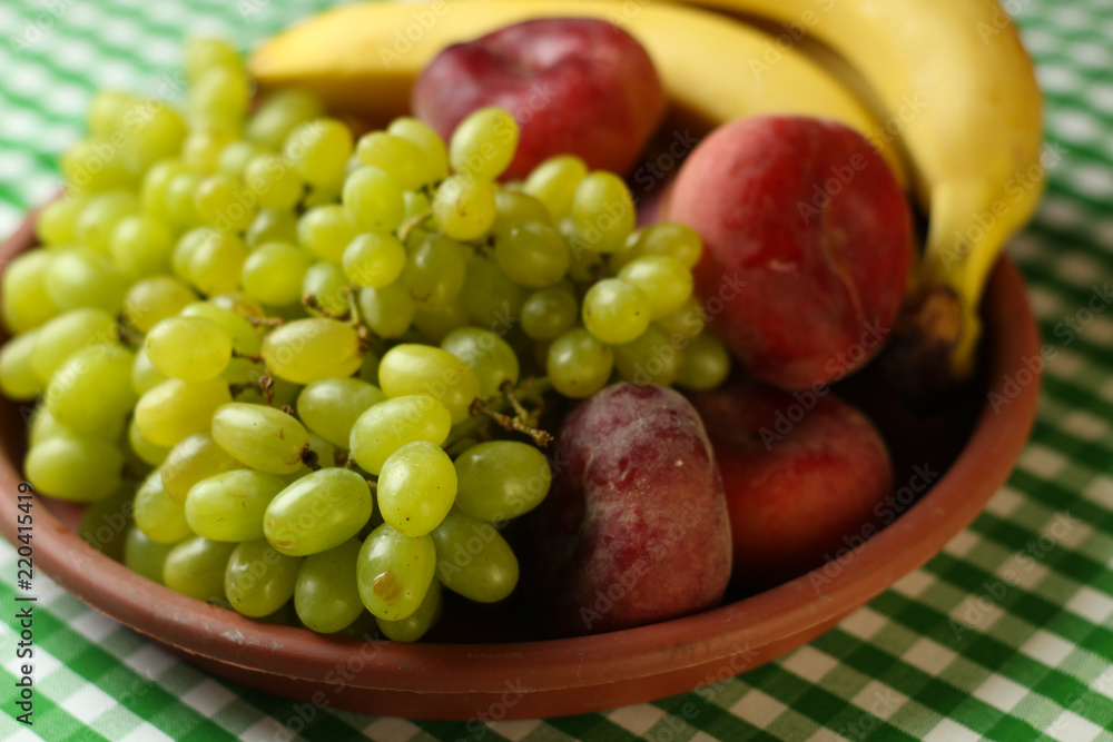 Fruit placement on white green cloth,with grapes, grapes, bananas, peaches in a glass plate. Fruit placement on white green cloth,with grapes, grapes, bananas, peaches in a glass plate.