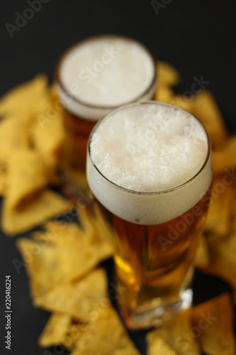 Light beer in a glass bowl on a black background.Beer in the bar and snacks, chips, nuts.