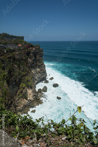 cliff steep with waves and surf in uluwatu temple blue water in bali indonesia