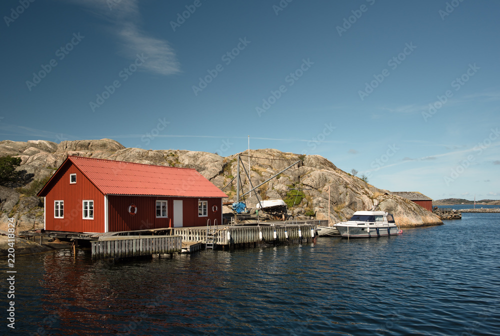 Marine lodge of red color on the rocky coast of a Swedish island.