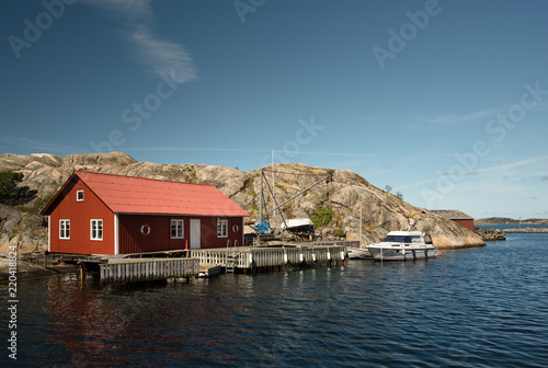 Marine lodge of red color on the rocky coast of a Swedish island.