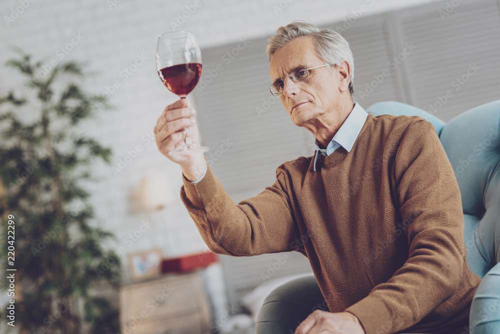 High quality. Concentrated taster raising his right arm while staring at glass bocal High quality. Concentrated taster raising his right arm while staring at glass bocal