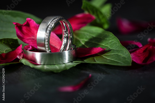 wedding ring band for bride and groom with additional ring with diamons, brilliants on leaves from flower photo