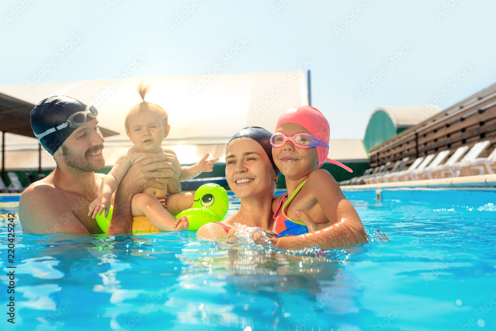 Happy family having fun by the swimming pool. Pool, leisure, swimming, summer, recreation, healthy lifstyle concept