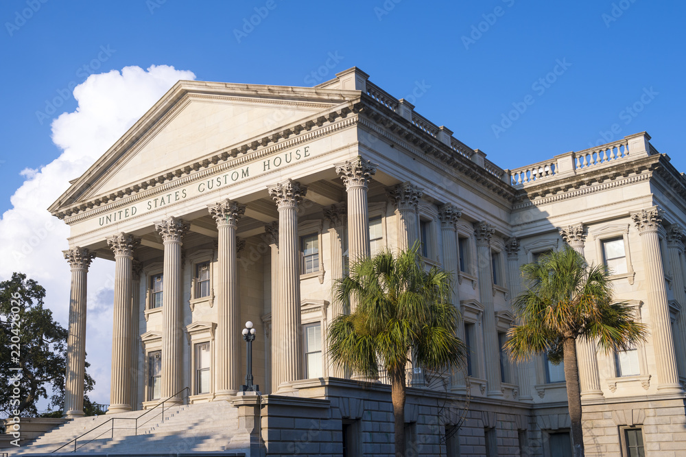 An old (mid 1800s) US government customs house with typical neoclassical architecture of a Roman portico supported by fluted corinthian columns.
