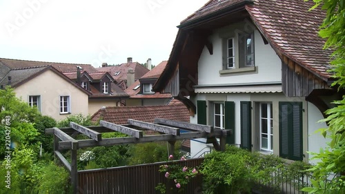 Medieval town of Laupen, Switzerland near Bern. Pan up from garden to the second floor of a timber framed house with other clay roofed homes in the distance. photo