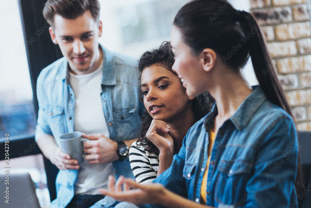 Valuable proposition. Appealing three students studying while talking Valuable proposition. Appealing three students studying while talking