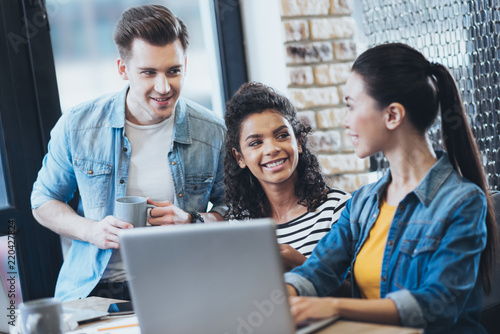 Group discussion. Energetic three students studying while grinning