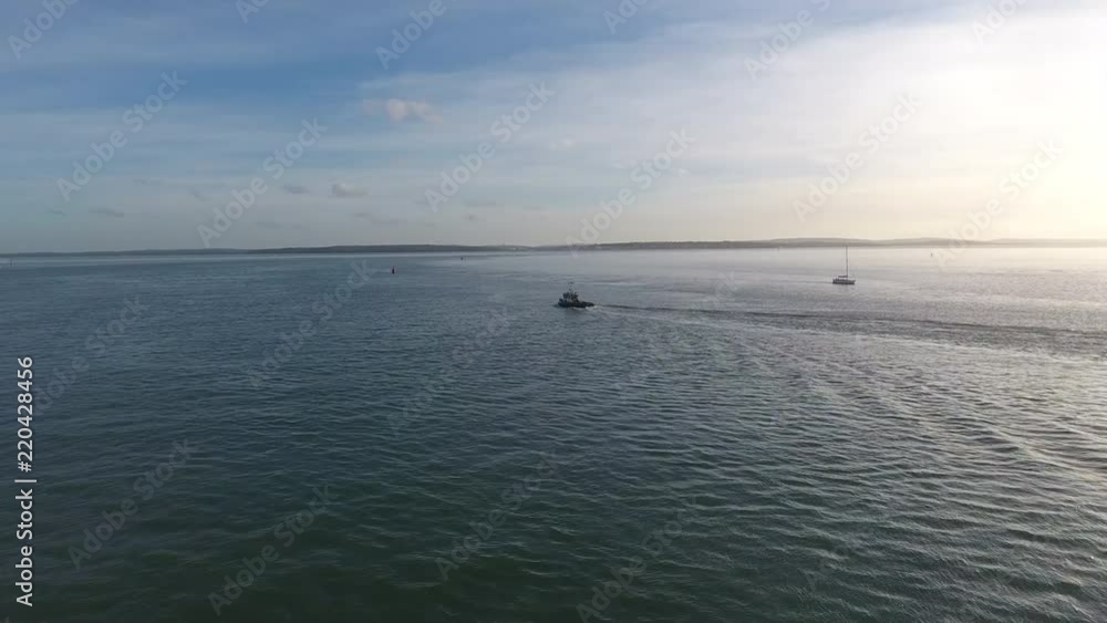 4K Aerial of small tub boat passing calshot near Southampton in the solent. 4K Aerial of small tub boat passing calshot near Southampton in the solent.