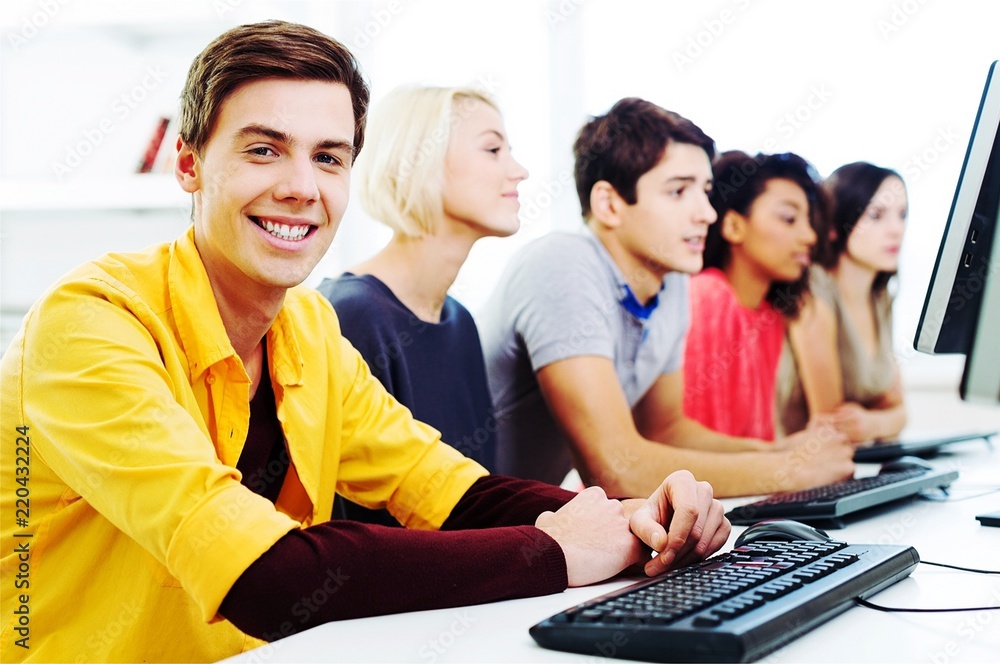 Group of Students with computers at lesson in classroom Group of Students with computers at lesson in classroom