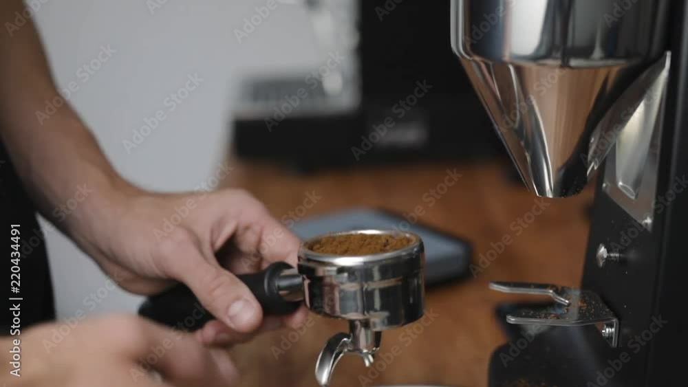 Home barista checks weight of coffee and tamps the grounded coffee in portafilter. Home barista checks weight of coffee and tamps the grounded coffee in portafilter.