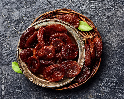 Dried brown apricots on gray background. Top view. photo