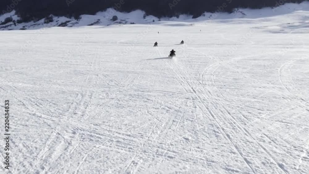 Drone Flying over a group of friends having fun on a snowmobile Drone Flying over a group of friends having fun on a snowmobile