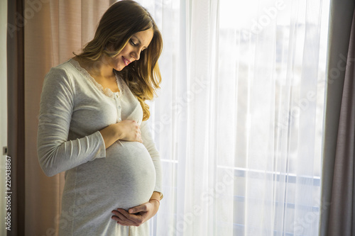 Fototapeta Young pregnant woman by the window