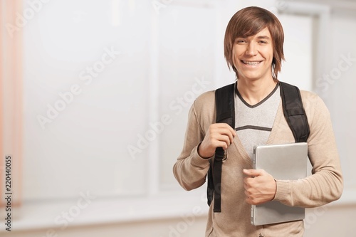 Male student with backpack on background