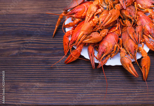 a large plate of boiled crawfish and a mug of light beer on a wooden background