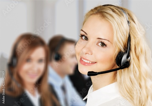 Female call center employee with coworkers on background